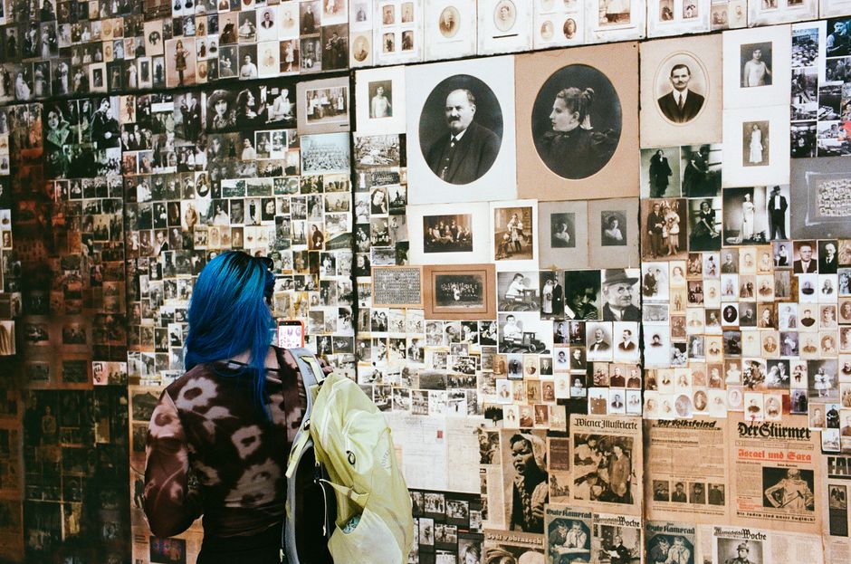 A visitor examining archival and vintage photographs at a Venice art exhibit.